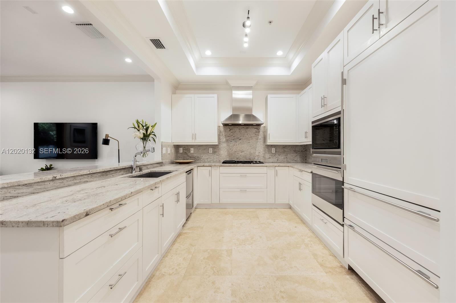 A white kitchen features granite countertops, stainless steel appliances, and light-colored tile flooring — 7430 SW 56th Ct, Miami FL 33143, MIAMI, FL
