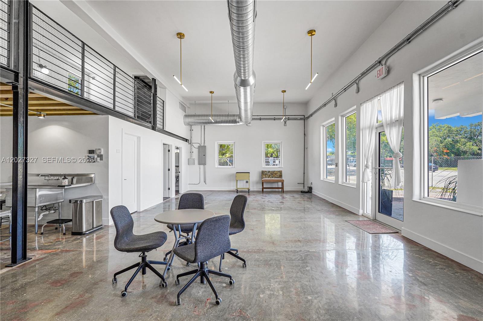An open-plan commercial space features polished concrete floors, exposed ductwork, and a small kitchenette — 798 NW 62nd St, Miami FL 33150, MIAMI, FL