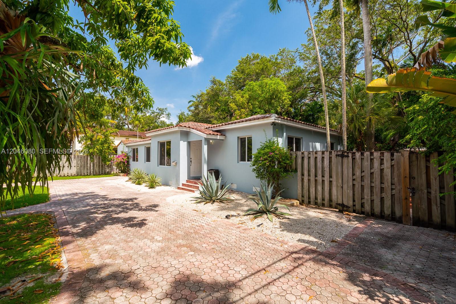A light blue, single-story house with a tiled roof sits behind a paved driveway — 2215 Tequesta Ln, Miami FL 33133, MIAMI, FL
