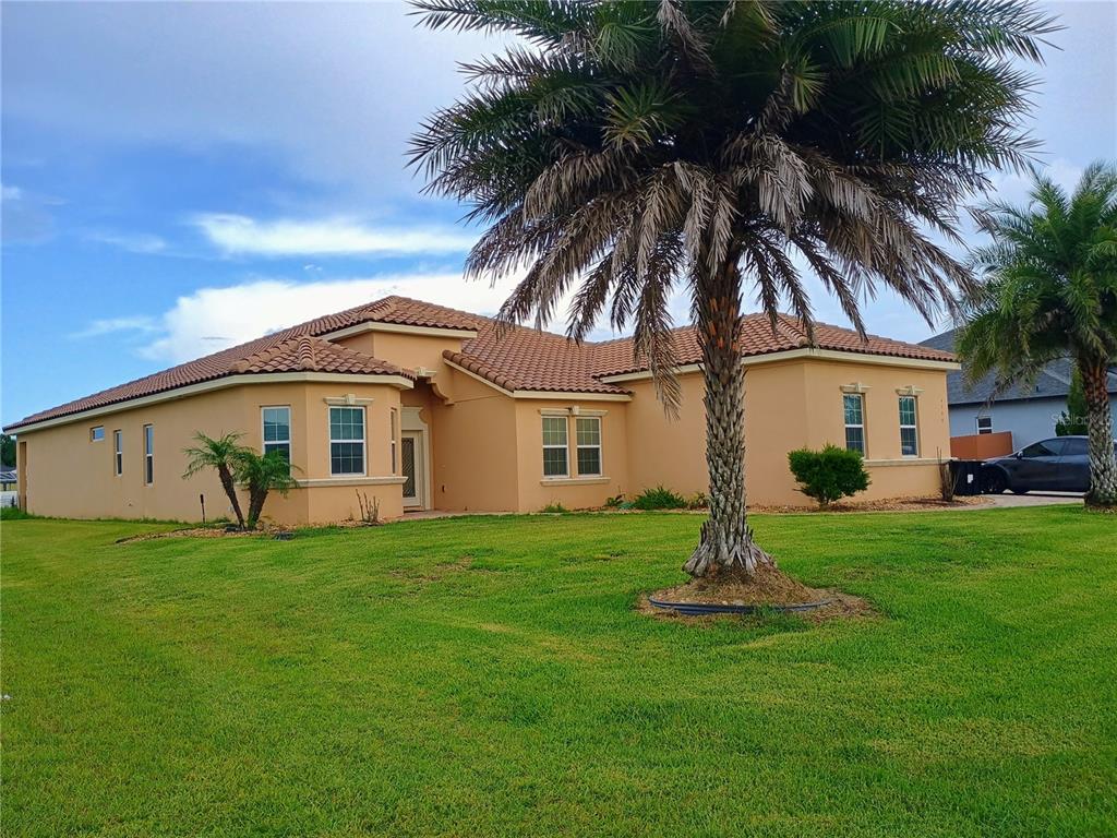 A single-story tan stucco house with a tiled roof and a large palm tree — 4394 PRESERVATION CIRCLE, MELBOURNE, FL