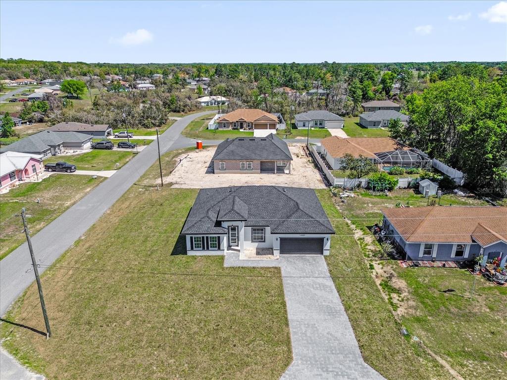 An aerial view shows a newly constructed house with a paved driveway and surrounding neighborhood — 14889 SW 24TH CIRCLE, OCALA, FL