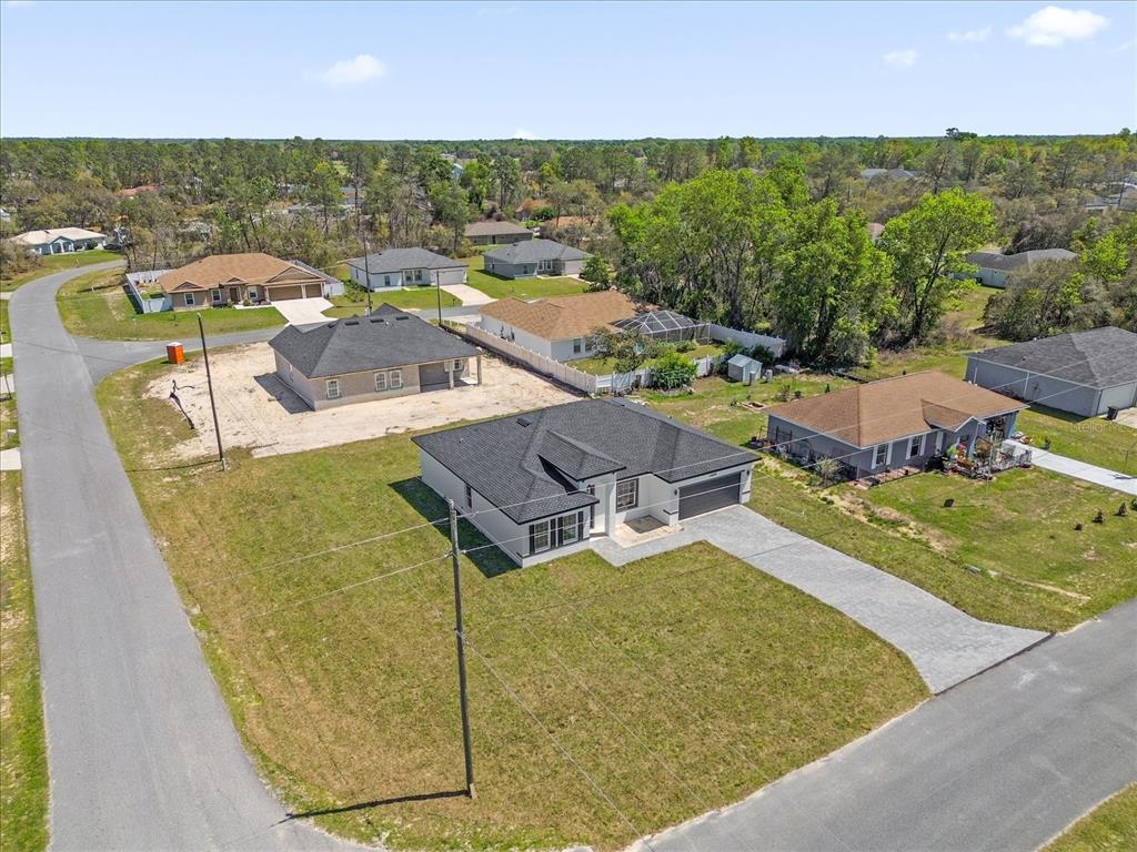 An aerial view shows a newly constructed house with a dark roof and paved driveway — 14889 SW 24TH CIRCLE, OCALA, FL
