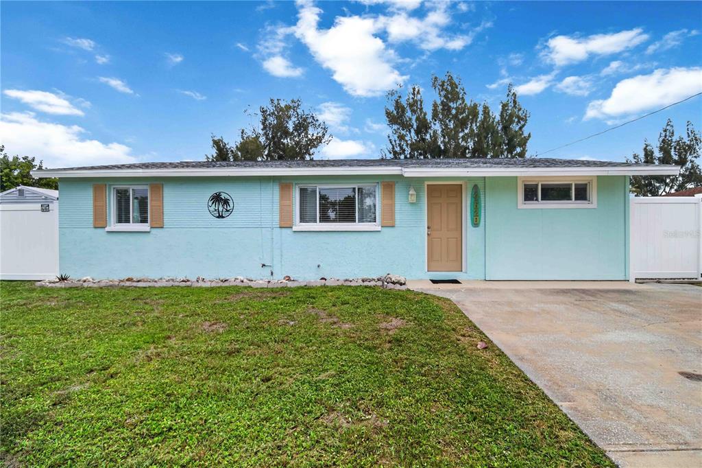 A single-story light blue house with a tan front door and a concrete driveway — 4620 3RD AVENUE W, PALMETTO, FL