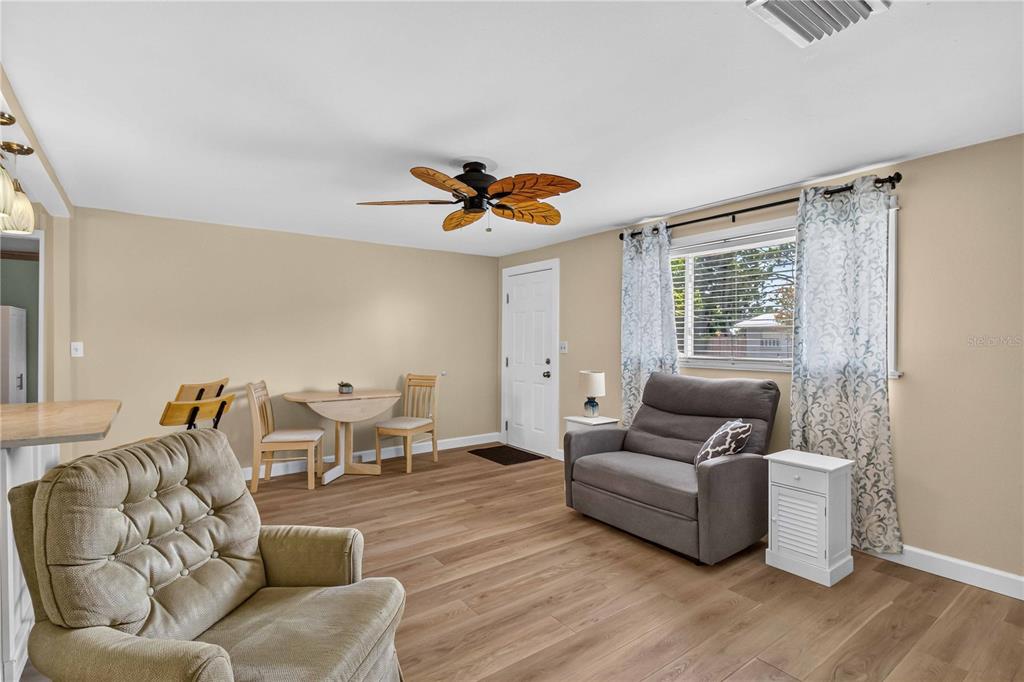 A living room features light wood-look flooring, a ceiling fan, and a small dining set — 4620 3RD AVENUE W, PALMETTO, FL