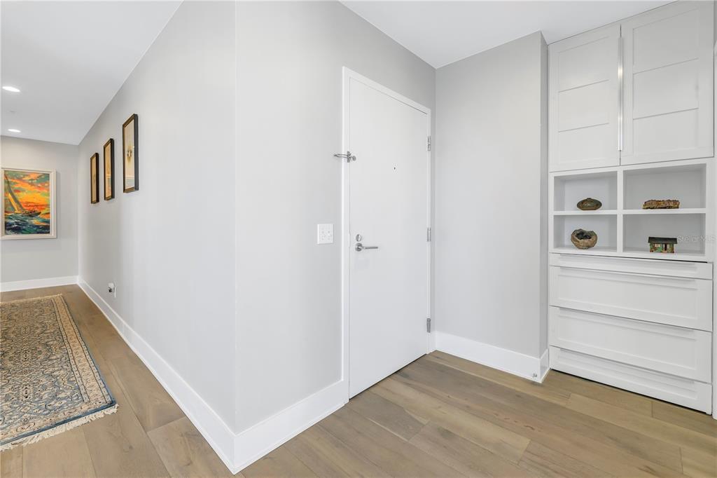 A white door stands next to a built-in white cabinet in a light-floored entryway — 175 1ST STREET S UNIT 1006, ST PETERSBURG, FL