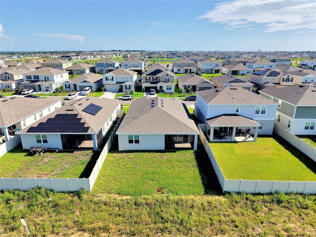 An aerial view shows the backyards and rear exteriors of several suburban residential houses — 3324 CHICORY COURT, LAKE HAMILTON, FL