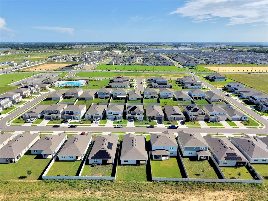 An aerial view shows a suburban neighborhood with rows of houses and a community pool — 3324 CHICORY COURT, LAKE HAMILTON, FL