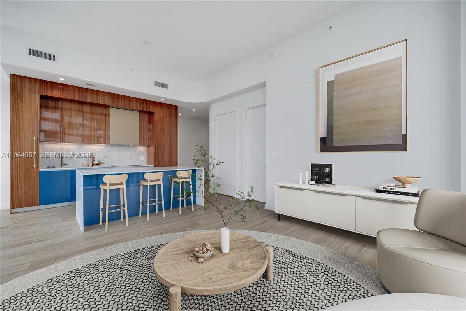 A modern kitchen with blue cabinets and wood accents opens into a living area — 2655 S Bayshore Dr # 1709, Miami FL 33133, MIAMI, FL