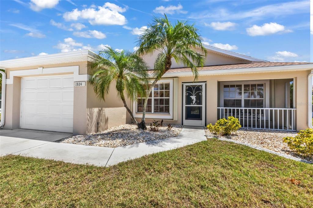 A single-story house with a white garage, palm trees, and a front porch — 1924 BODDINGTON TRAIL, PUNTA GORDA, FL
