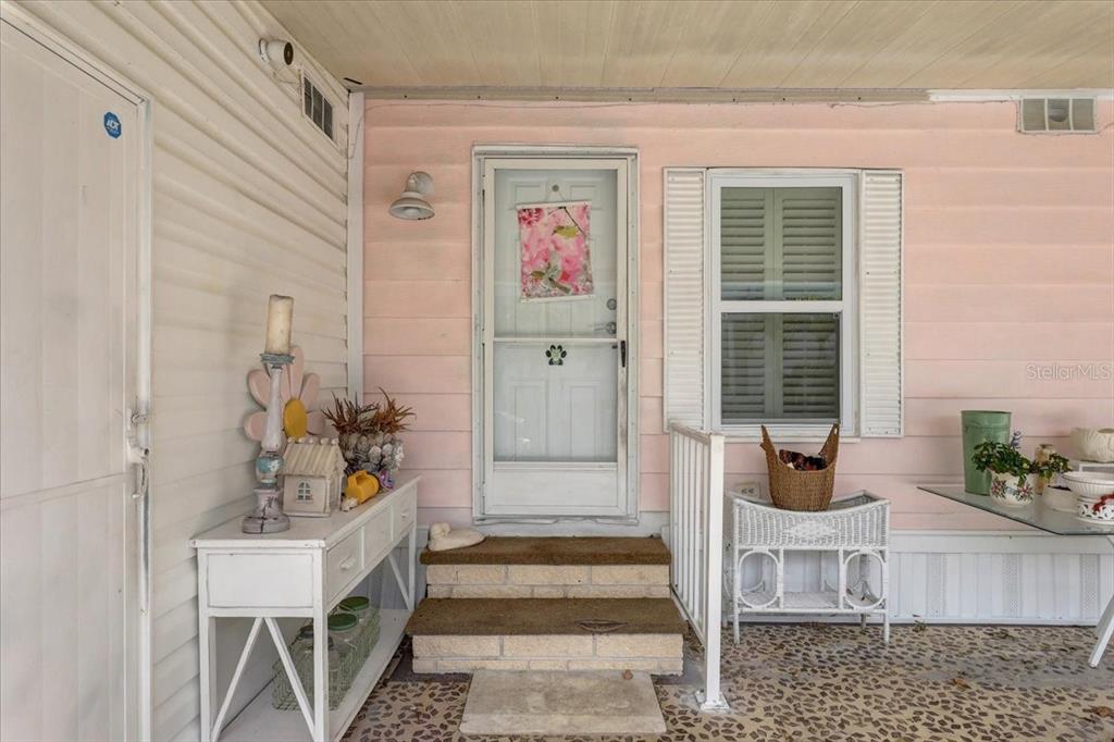 A pink exterior wall features a front door, a window, and a small porch area — 174 CLUBVIEW DRIVE UNIT 4, SAFETY HARBOR, FL
