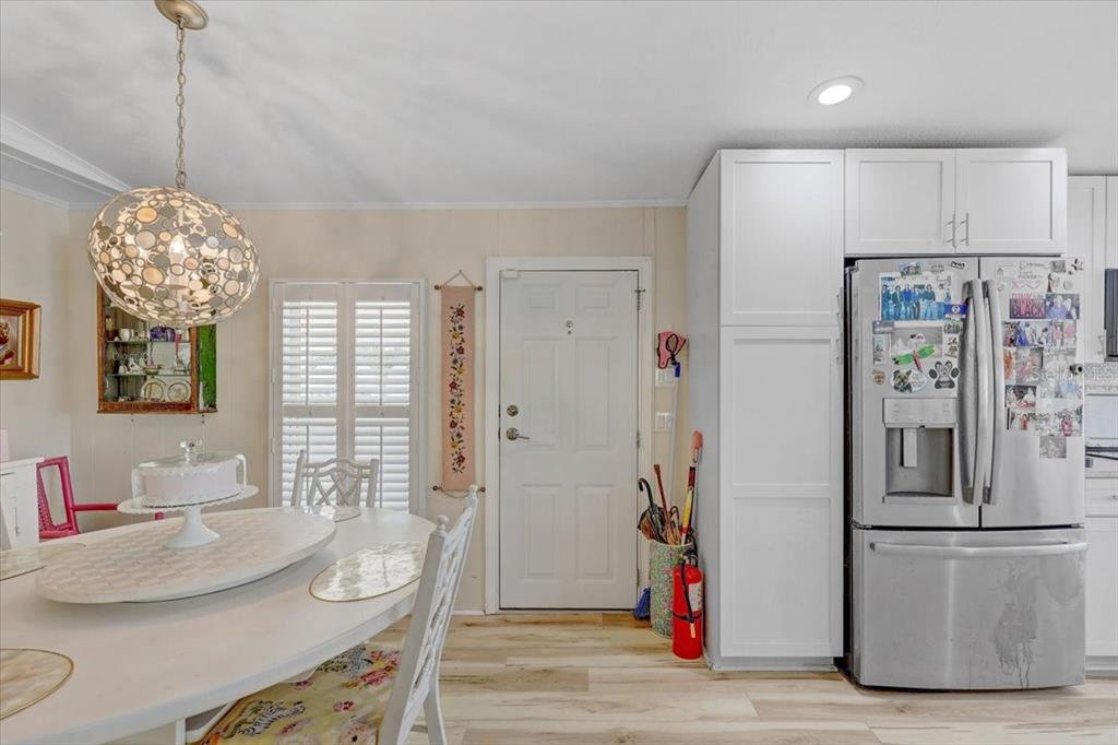 A dining area features a white table, a decorative pendant light, and a stainless steel refrigerator — 174 CLUBVIEW DRIVE UNIT 4, SAFETY HARBOR, FL