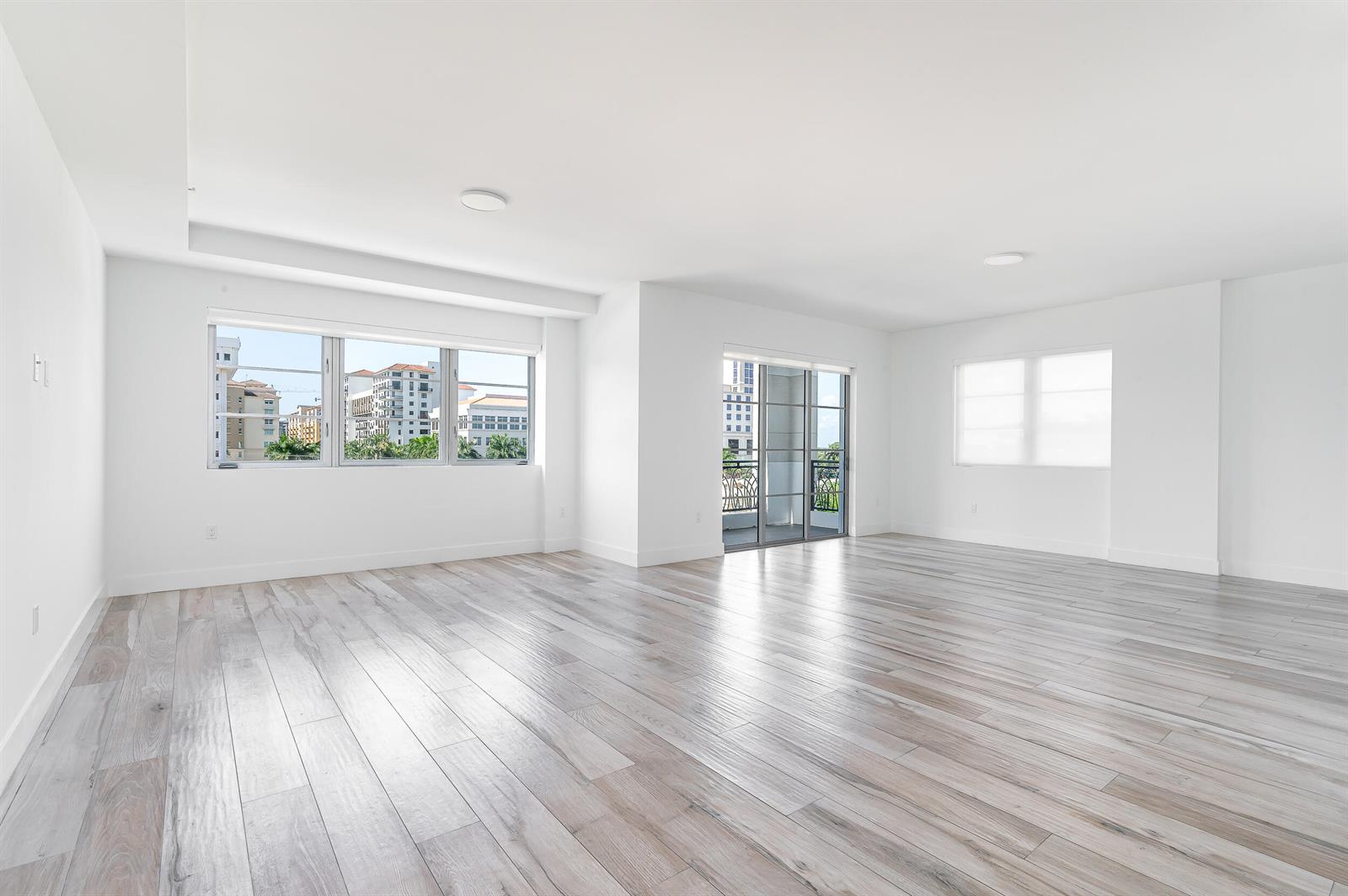 An empty, bright room features light wood-look flooring, white walls, and large windows with city views — 155 E Boca Raton Road # 516, Boca Raton FL 33432, BOCA RATON, FL