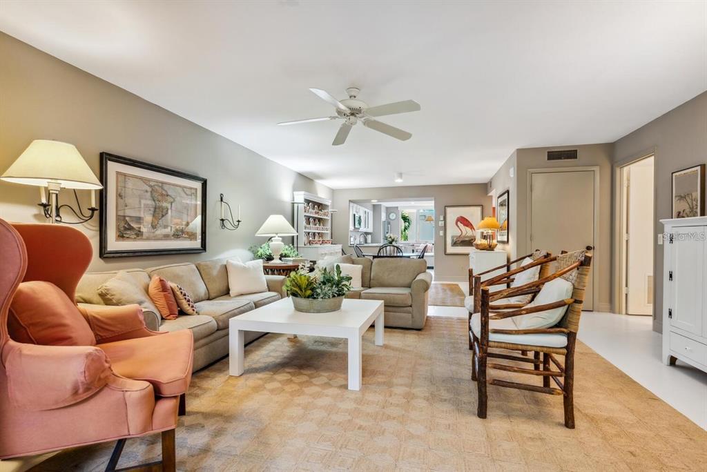 A living room features a beige sofa, a pink armchair, and a white coffee table — 840 BAYPORT WAY UNIT 840, LONGBOAT KEY, FL