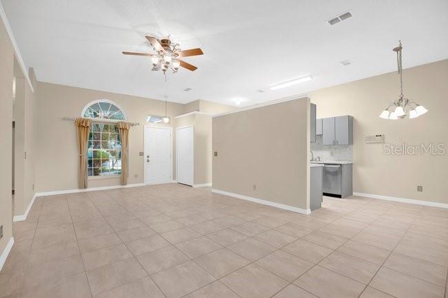 A dining area with a wooden table, six chairs, and a modern chandelier near a kitchen — 213 MILL SLOUGH ROAD, OVIEDO, FL
