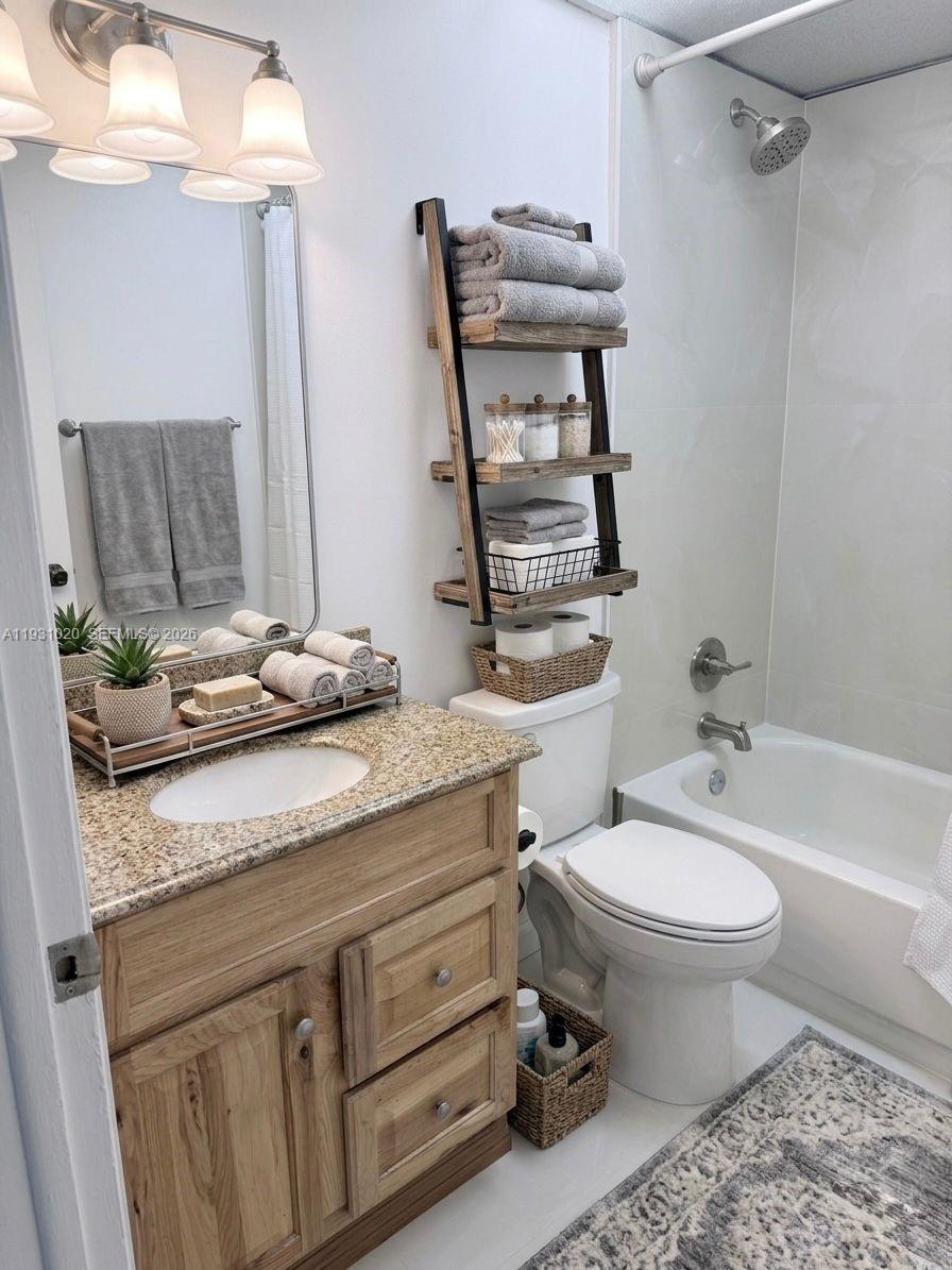 A bathroom features a wood vanity with a granite countertop, a ladder shelf, and a tub — 160 SW 30th Ave # 104A, Miami FL 33135, MIAMI, FL