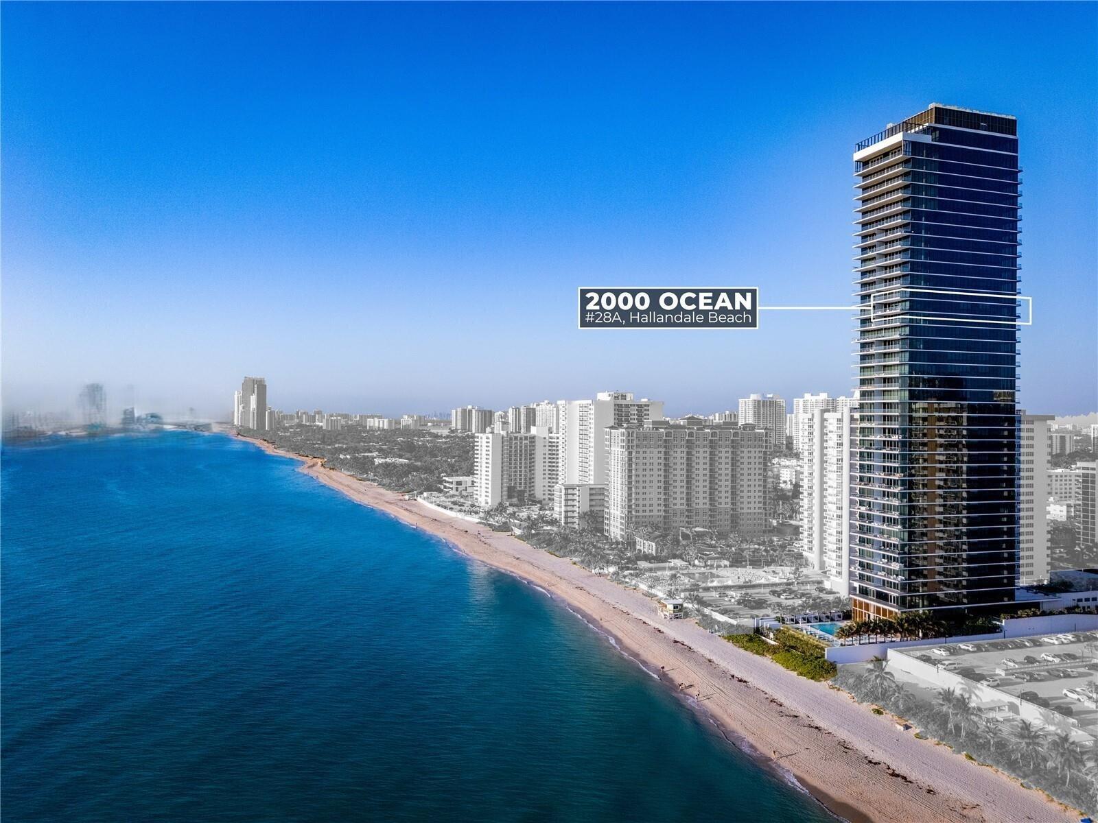 An aerial view shows a tall, modern glass residential tower situated on a sandy beach — 2000 S Ocean Drive SE # 5a, Hallandale Beach FL 33009, HALLANDALE BEACH, FL
