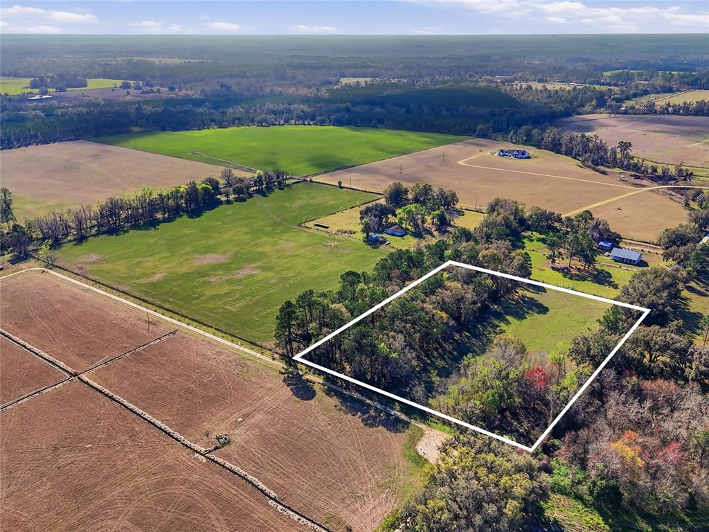 An aerial view shows a rectangular plot of land outlined in white amidst rural fields — NW COUNTY RD 239, ALACHUA, FL