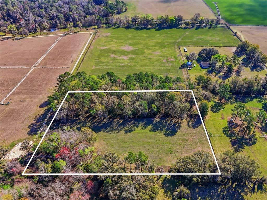An aerial view shows a rectangular plot of land outlined in white amidst rural fields — NW COUNTY RD 239, ALACHUA, FL