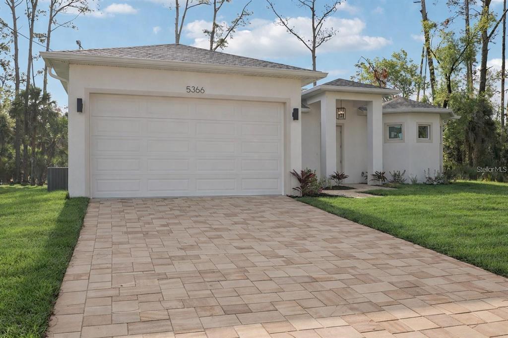 A single-story house with a white exterior, a two-car garage, and a paved driveway — 4338 JODY AVENUE, NORTH PORT, FL