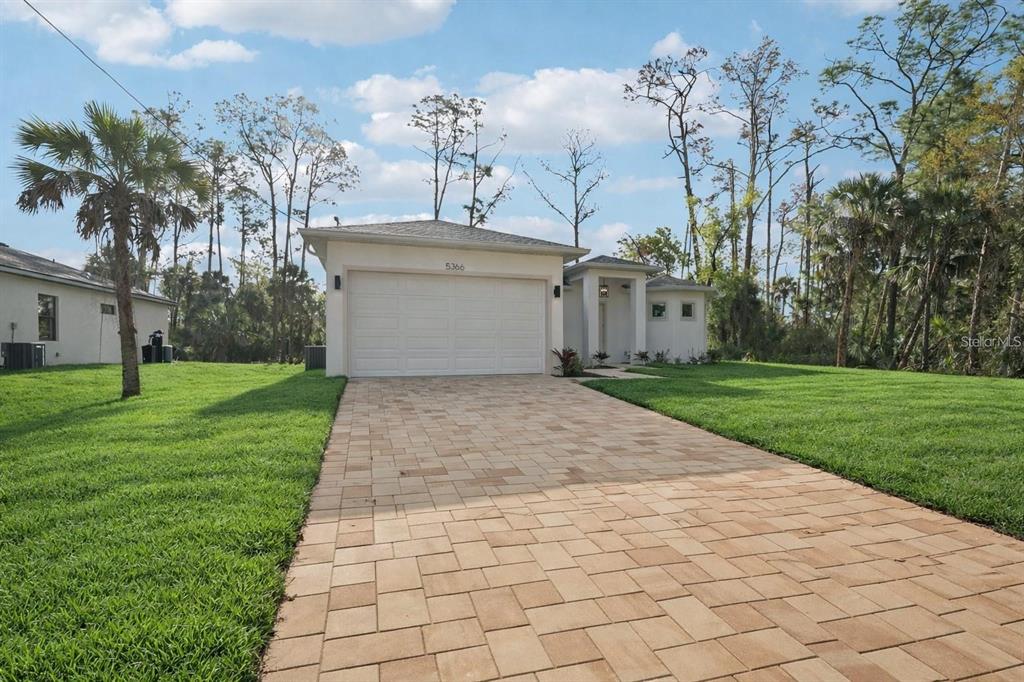 A single-story house with a paved driveway, a two-car garage, and a grassy front yard — 4338 JODY AVENUE, NORTH PORT, FL