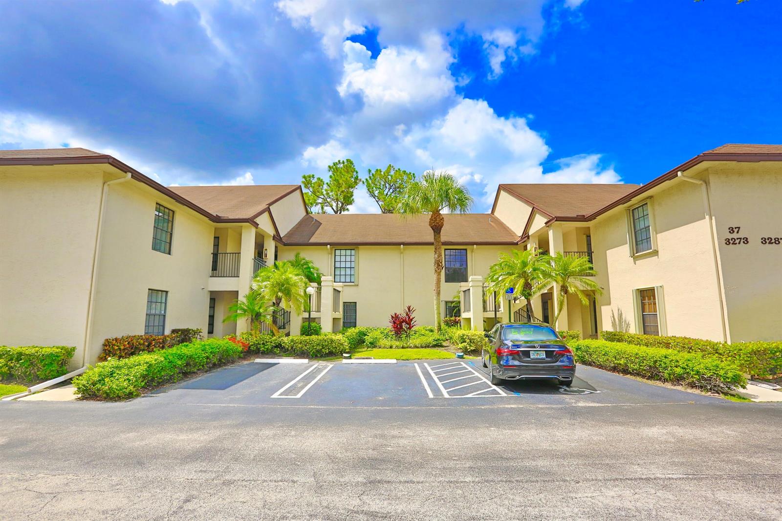 A two-story apartment building with beige stucco walls and a brown shingled roof — 3277 Jog Park Drive, FL 33467, FL