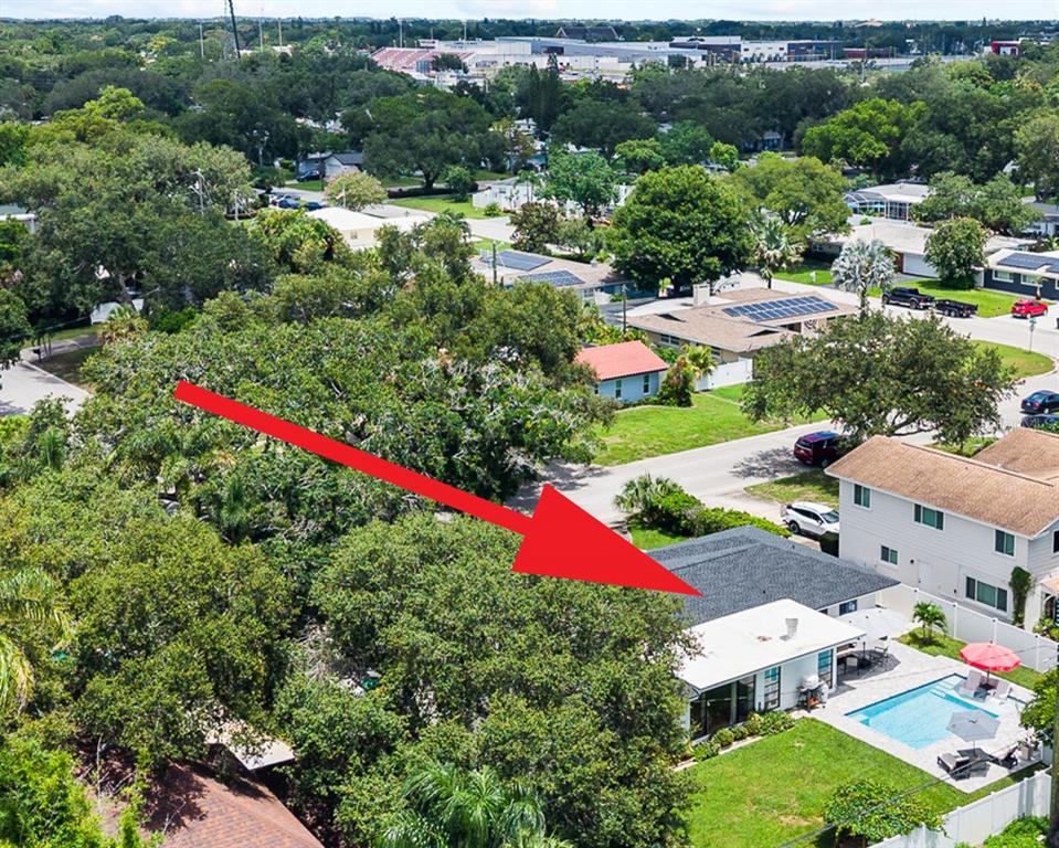 An aerial view shows a residential house with a swimming pool and a large backyard — 1821 OAK LAKE DRIVE, CLEARWATER, FL