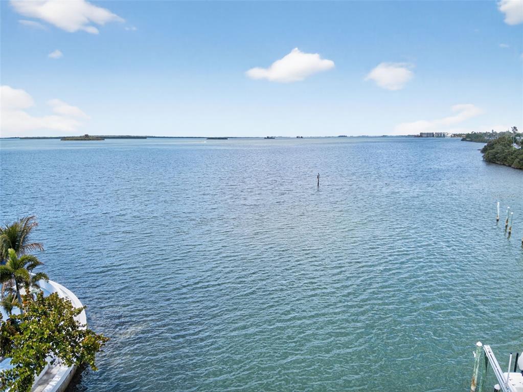 A wide-angle view of a calm bay with distant islands and a boat dock — 1866 VENETIAN POINT DRIVE, CLEARWATER, FL