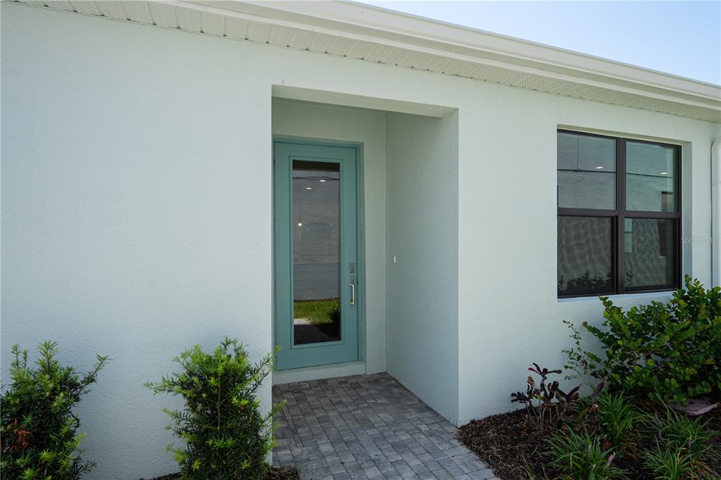 A light blue front door with a glass panel sits under a recessed entryway — 5854 WINDBREAK COURT, APOLLO BEACH, FL