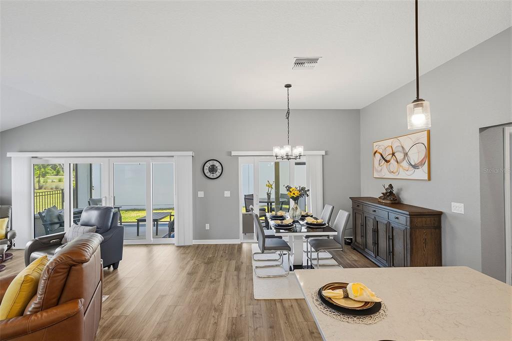 A dining area with a table and chairs sits adjacent to a living room — 6716 BUDDY LANE, THE VILLAGES, FL