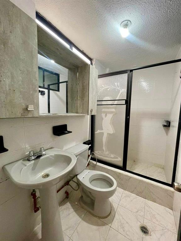 A bathroom features a pedestal sink, a toilet, and a shower with a decorative glass door — 77 FRANCISCO LECARO, LOJA/ECUADOR, OC