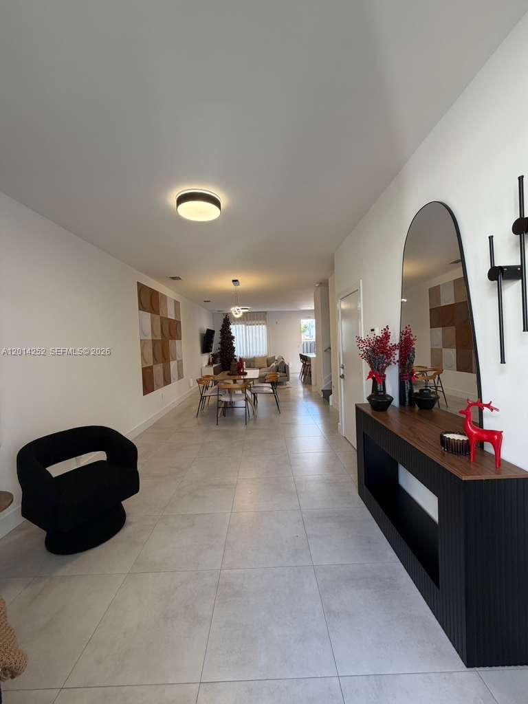 A long, open-concept living and dining area features light tile flooring and modern decor — 7187 NW 103 PATH # 7187, Miami FL 33178, MIAMI, FL