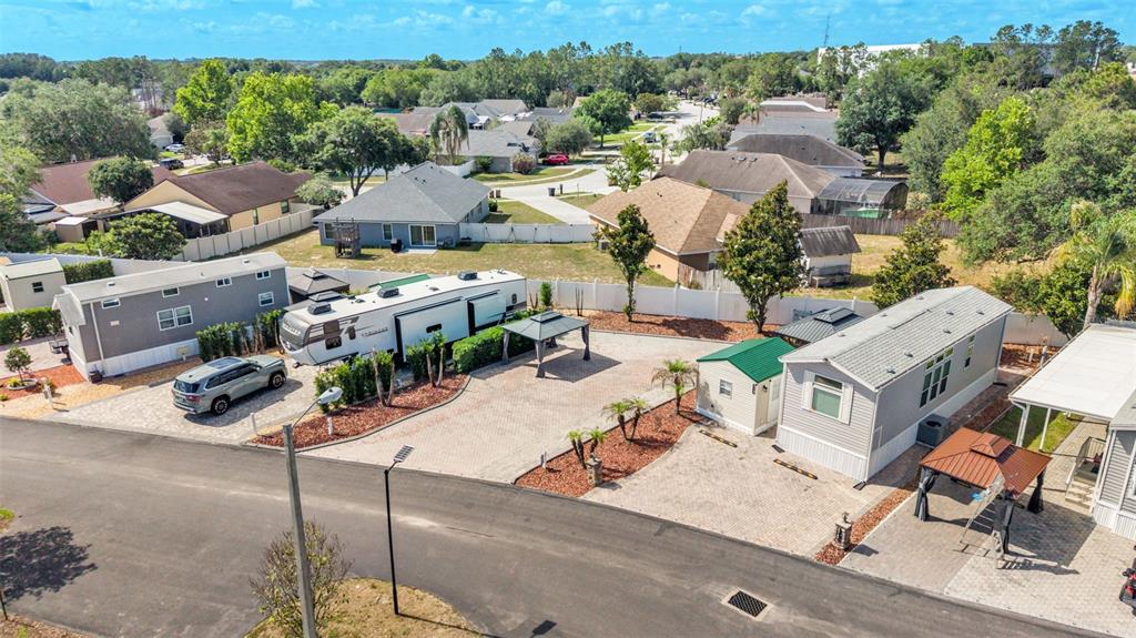 An aerial view shows a paved lot with a parked RV, two mobile homes, and gazebos — 2320 LIMEWOOD AVENUE, CLERMONT, FL