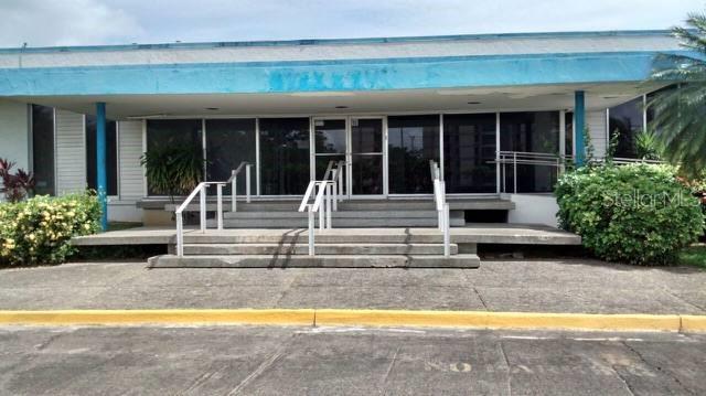 A low-rise commercial building features a blue roof, glass entrance doors, and concrete steps — 848 PR-848 INT. PR-887, CAROLINA, PR