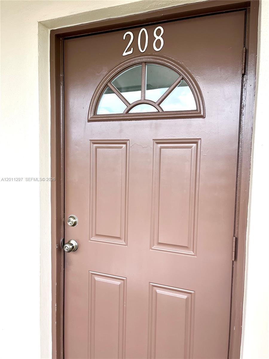 A brown front door with a semi-circular window and the number 208 above it — 551 NW 80th Ter # 208, Margate FL 33063, MARGATE, FL