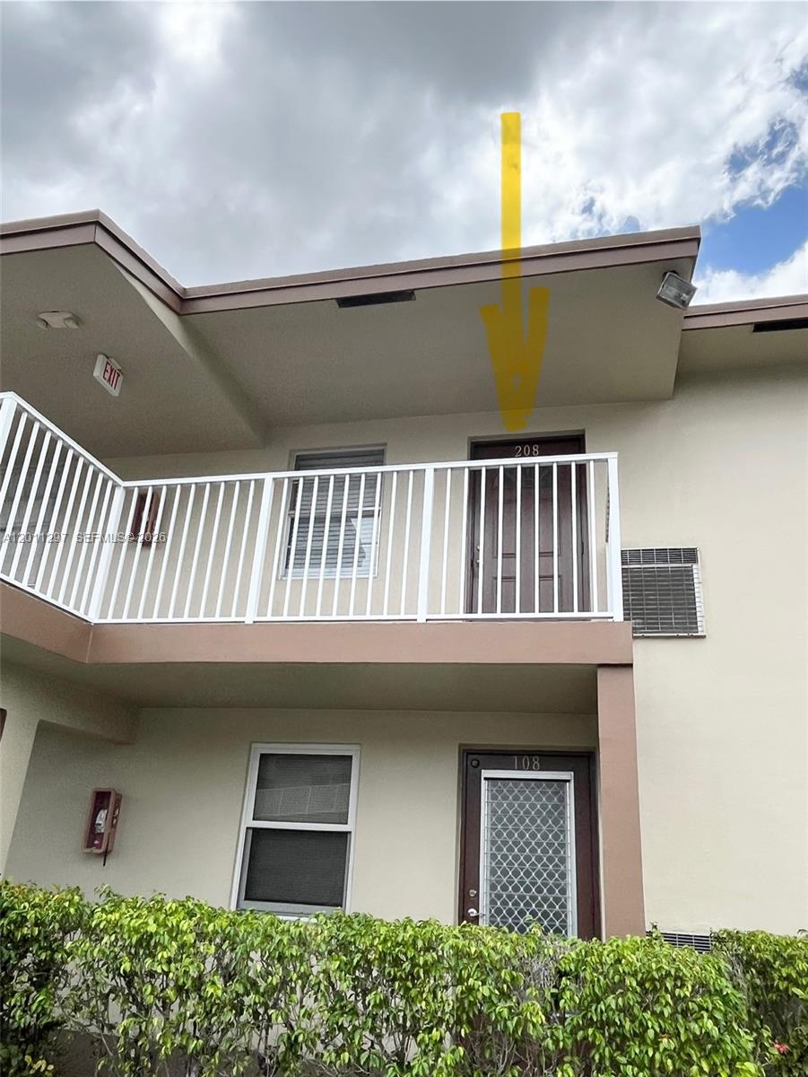 An exterior view of a two-story building featuring a balcony and two numbered doors — 551 NW 80th Ter # 208, Margate FL 33063, MARGATE, FL