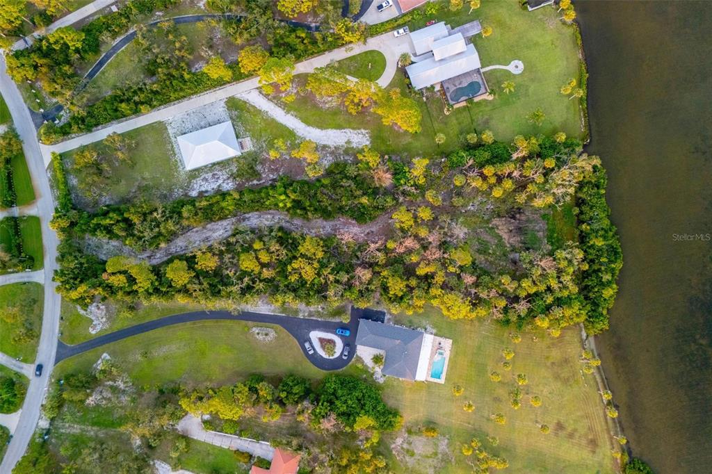 An aerial view shows two waterfront houses separated by a large, wooded lot — BAYSHORE DRIVE, ENGLEWOOD, FL