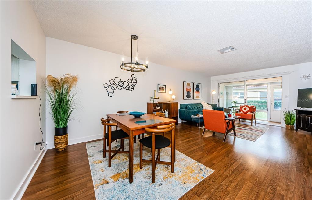 A dining area and living room with wood floors, a chandelier, and a sliding glass door — 601 N HERCULES AVENUE UNIT 508, CLEARWATER, FL