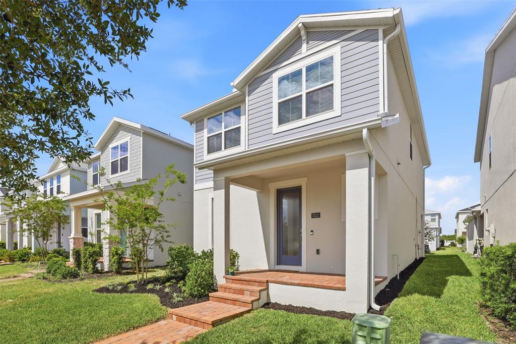 A two-story suburban house with a covered front porch and a brick walkway — 2512 CEDAR ROSE STREET, APOPKA, FL