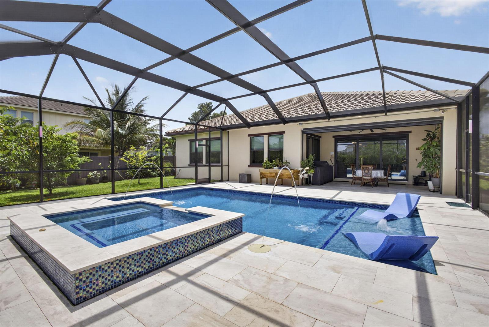 A screened-in patio features a swimming pool with a spa, fountains, and lounge chairs — 1010 Sweetgrass Street, Loxahatchee FL 33470, LOXAHATCHEE, FL