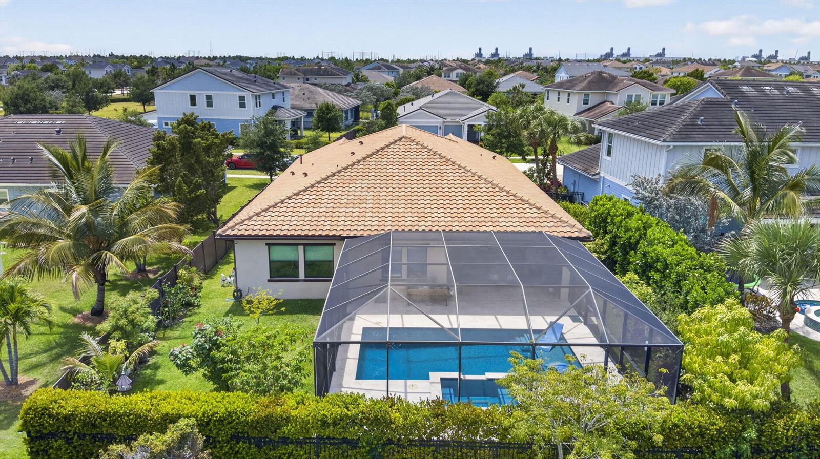 An aerial view of a house with a tiled roof, pool, and screened-in patio — 1010 Sweetgrass Street, Loxahatchee FL 33470, LOXAHATCHEE, FL