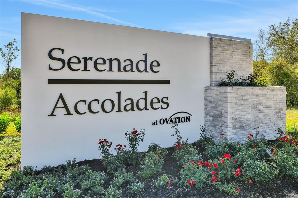 A two-story house with teal vertical siding, a front porch, and a stone-accented entryway — 13031 SERENE GLADE ROAD, WINTER GARDEN, FL
