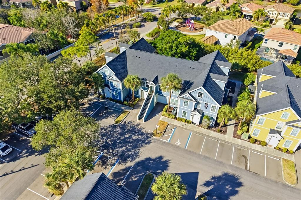 A blue multi-story apartment building with a parking lot and trees in the foreground — 5501 ROSEHILL ROAD UNIT 103, SARASOTA, FL