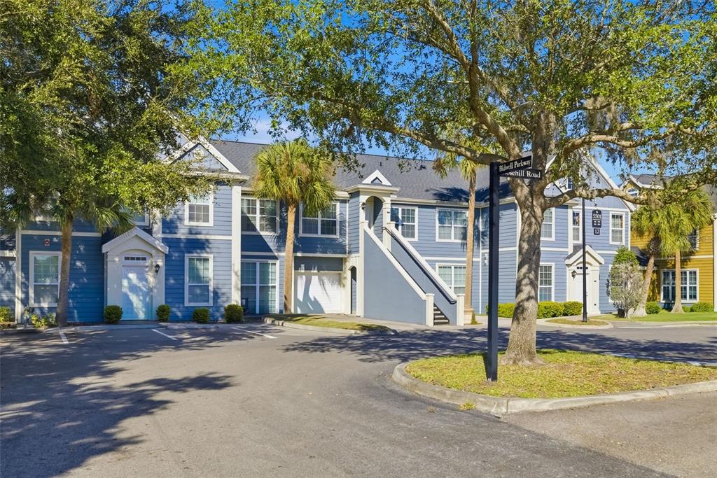 An aerial view shows a blue multi-unit residential building with parking spaces in front — 5501 ROSEHILL ROAD UNIT 103, SARASOTA, FL