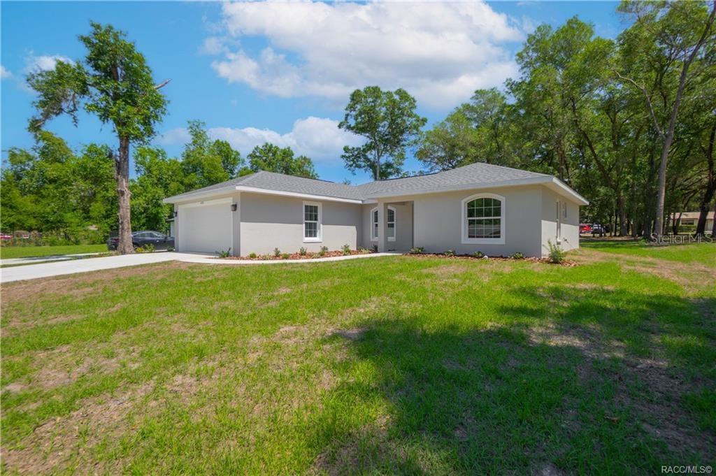 A single-story house with a light-colored exterior, a two-car garage, and a grassy yard — 605 N CORBIN AVENUE, INVERNESS, FL