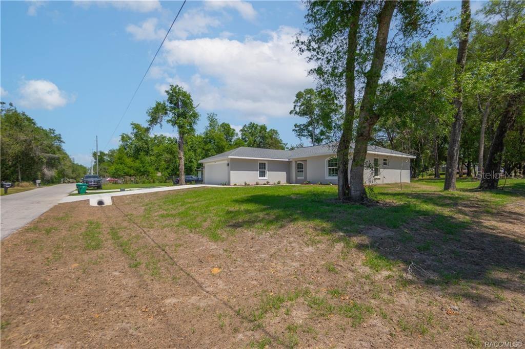A single-story gray house with a garage sits on a grassy lot with trees — 605 N CORBIN AVENUE, INVERNESS, FL