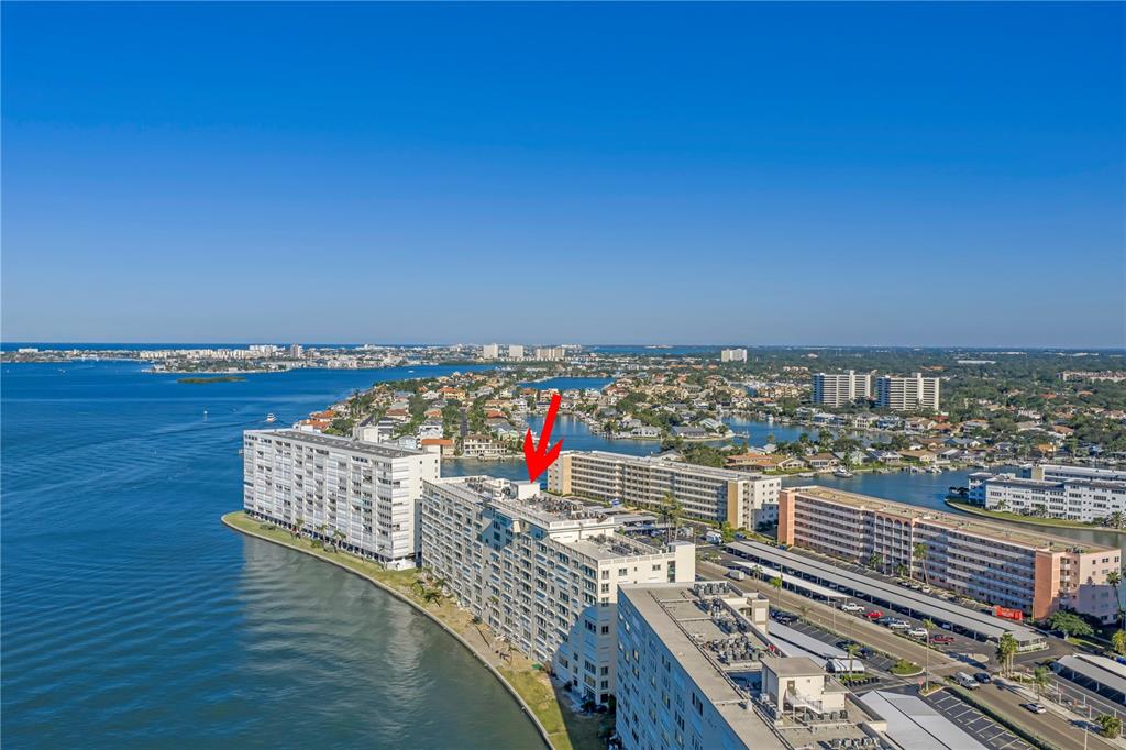 An aerial view shows several large waterfront apartment buildings along a coastal bay — 6020 SHORE BOULEVARD S UNIT 712, GULFPORT, FL