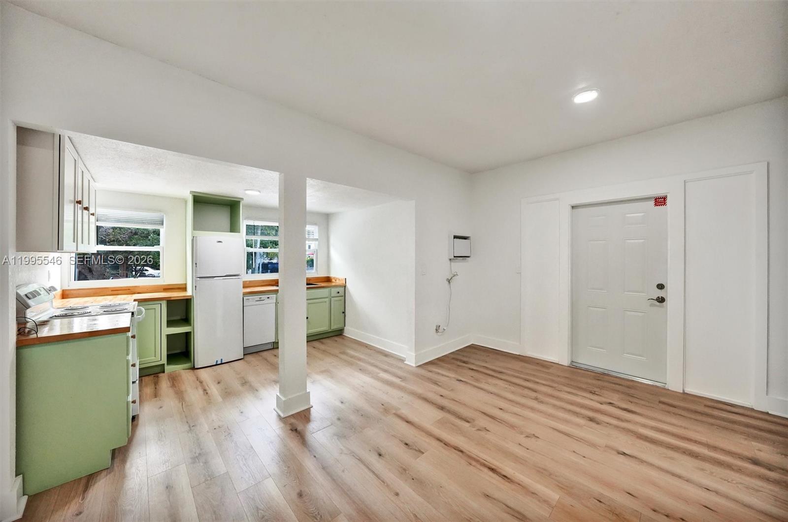 A kitchen with light green cabinets and wood countertops opens into a living area — 1411 SW 3rd st # 2, Miami FL 33135, MIAMI, FL