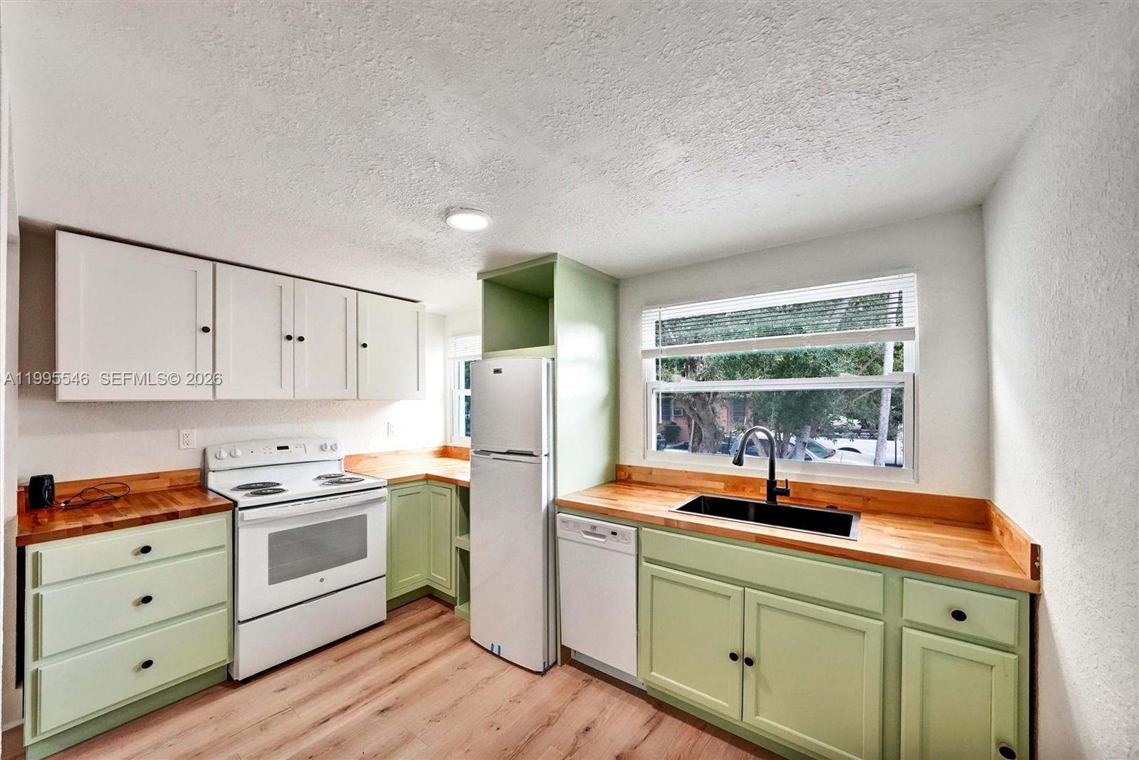 A kitchen features light green cabinets, butcher block countertops, white appliances, and a black sink — 1411 SW 3rd st # 2, Miami FL 33135, MIAMI, FL