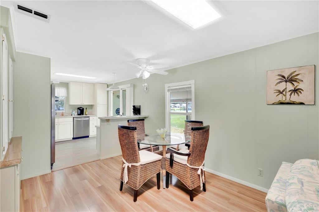A dining area with a glass table, wicker chairs, and light green walls — 2527 LONGPINE LANE, ST CLOUD, FL