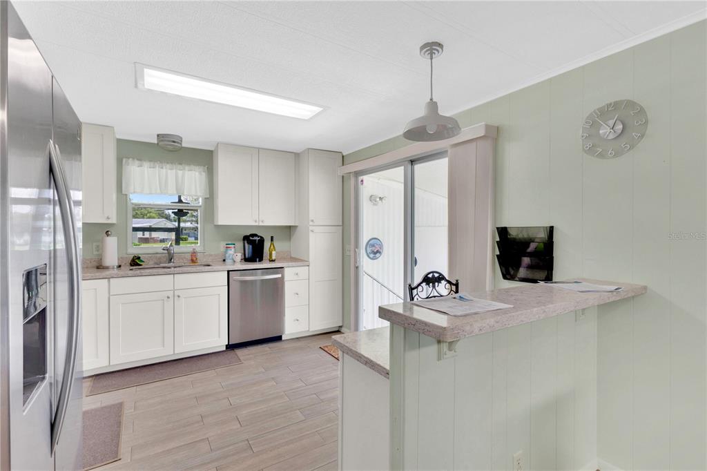 A kitchen with white cabinets, stainless steel appliances, and a breakfast bar — 2527 LONGPINE LANE, ST CLOUD, FL